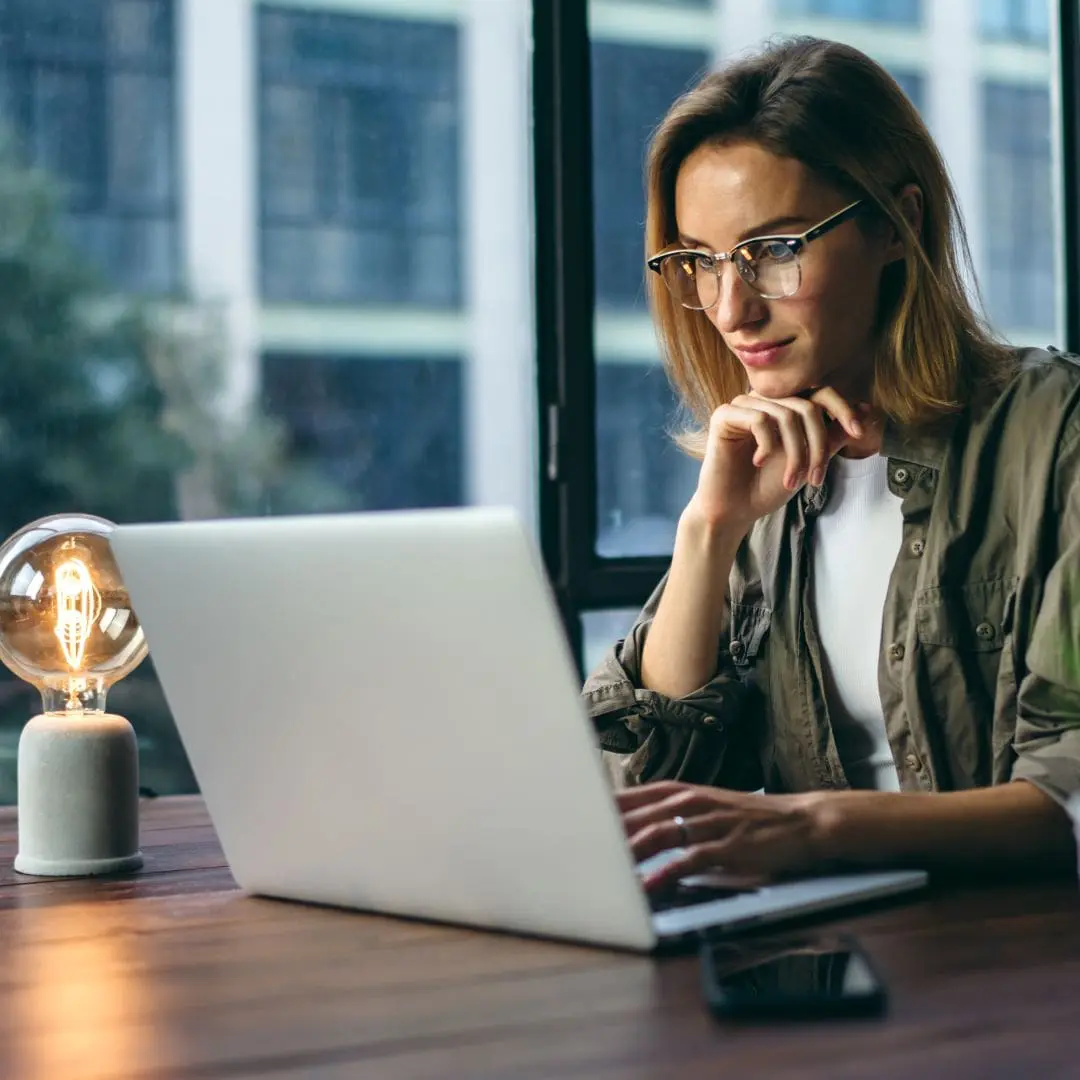 salesperson improving her skills by reading on laptop computer